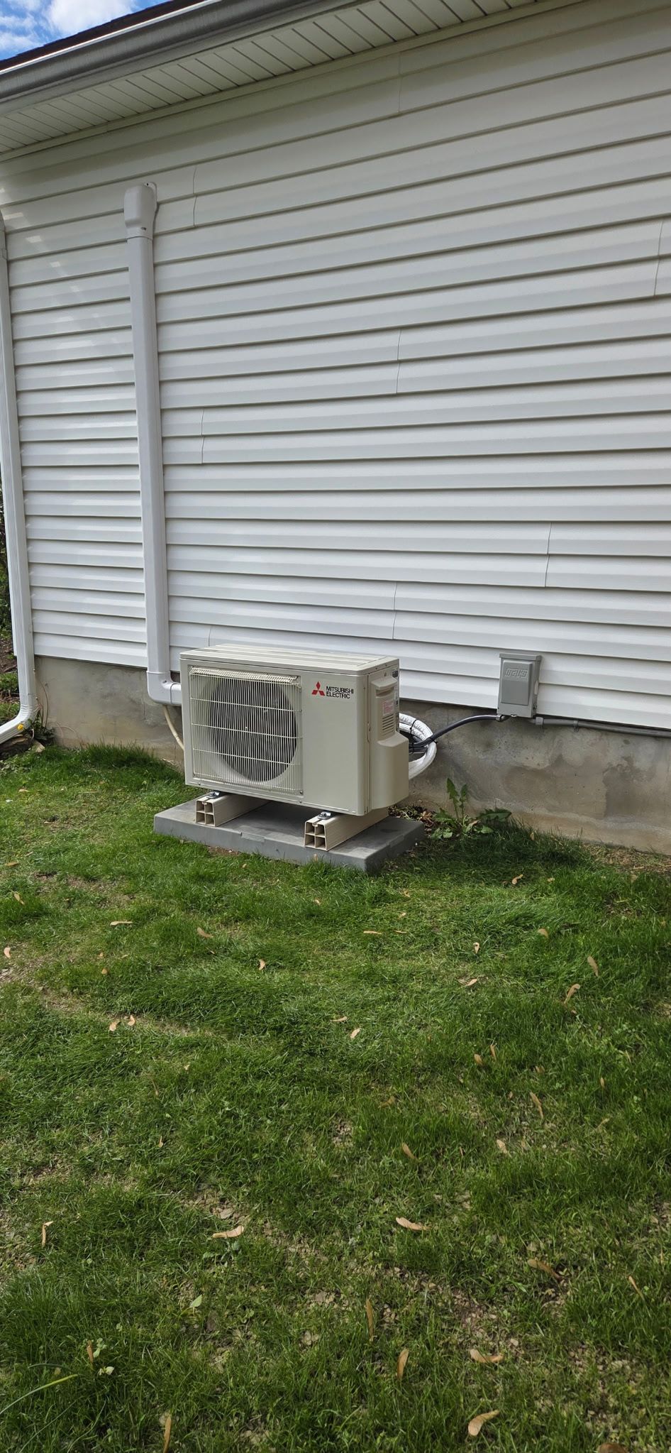 Mitsubishi Electric ductless mini-split heat pump installed beside a home by Keystone Property Service